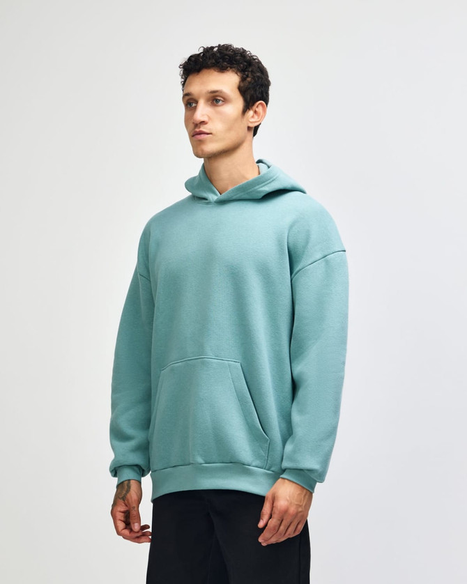 A unisex hooded sweatshirt in a soft green shade, featuring a front pouch pocket and a branded logo.