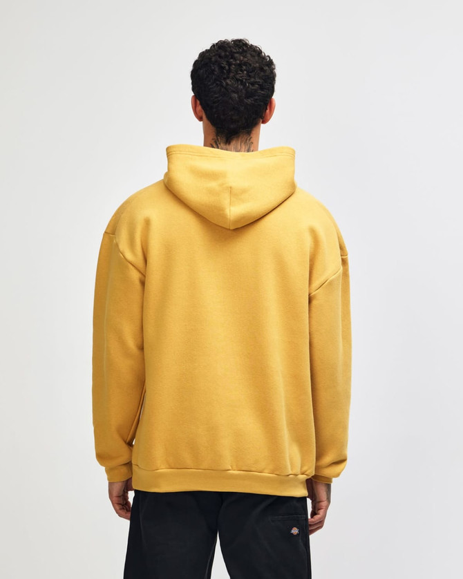 A unisex hooded sweatshirt in mustard yellow, featuring a spacious fit and a hood at the back. It has a branding logo.