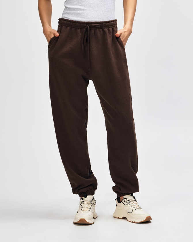 Brown unisex sweatpants with an elastic waistband and drawstring, featuring a relaxed fit and a logo.