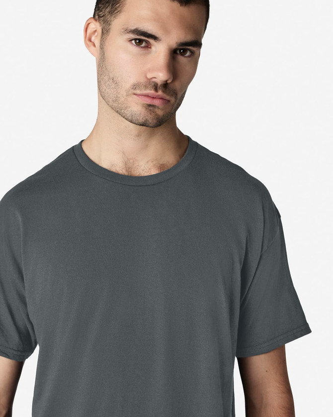A model wearing a grey Gildan Light Cotton T-Shirt, featuring a classic crew neck and short sleeves.
