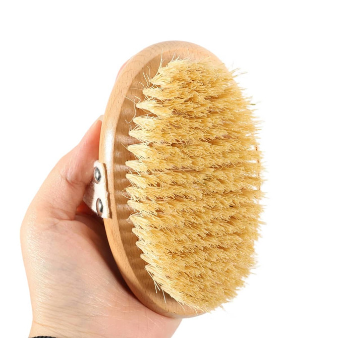 A sisal wooden brush held in a hand, featuring a light wooden base and natural bristles.