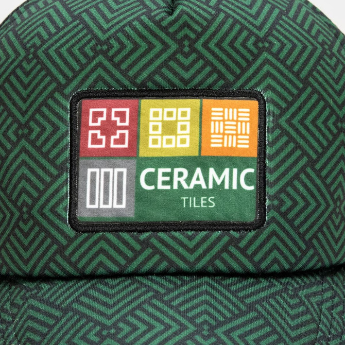 A green trucker cap featuring a full colour patch with a geometric design and the words "Ceramic Tiles."