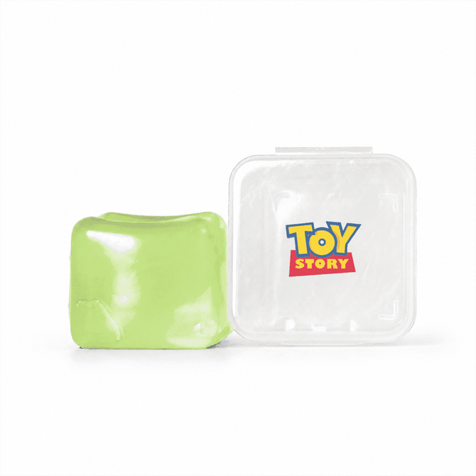 A green jelly cube sensory toy next to a clear container featuring a logo.