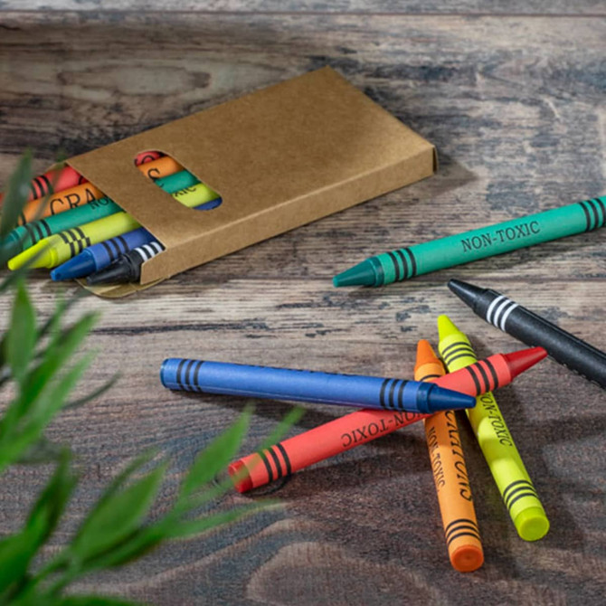 A crayon set featuring six vibrant colours in a cardboard box, with some crayons scattered on a wooden surface.