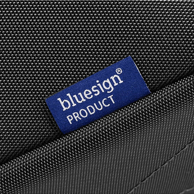 A textured black toiletry bag with a blue label indicating it is a bluesign product.
