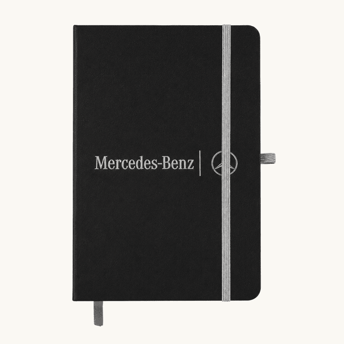 A black A5 notebook with an elastic closure and a logo on the front, featuring a grey band and bookmark.