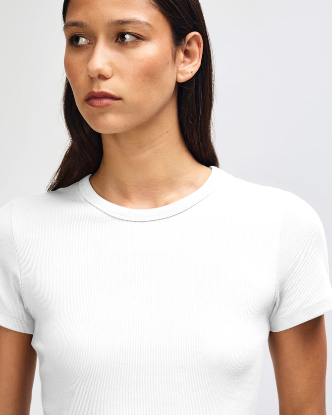 A fitted white women's crop t-shirt with short sleeves and a round neck, featuring a logo.