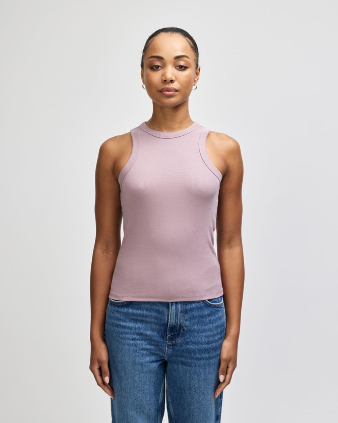 A fitted tank top in a soft mauve colour, featuring sleeveless design and a logo. Paired with blue jeans.