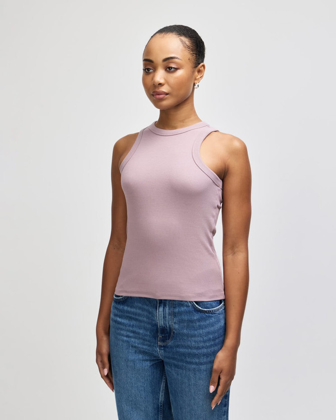A fitted tank top in mauve, featuring a cut-out shoulder design, paired with blue jeans.