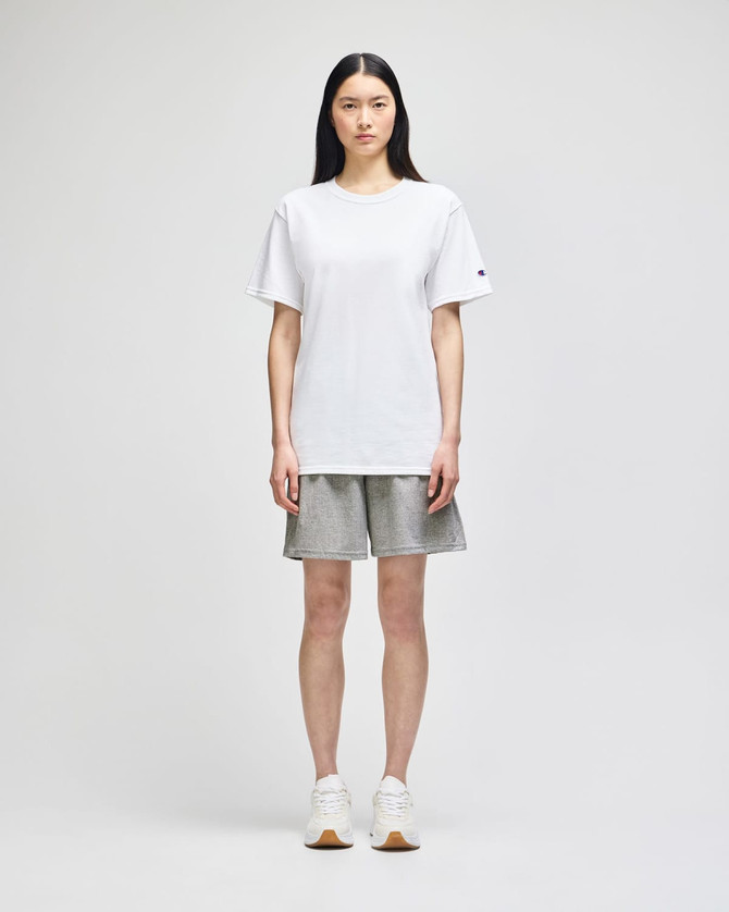 A model wearing grey cotton gym shorts and a white t-shirt, standing against a neutral background.