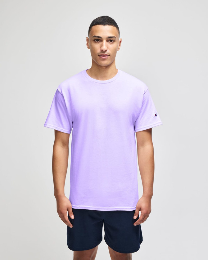 A purple Champion Adult Jersey Short Sleeve T-Shirt displayed on a model wearing navy shorts. The shirt features a logo.