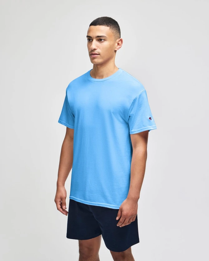 A light blue short sleeve T-shirt on a model, paired with dark shorts, featuring a logo on the sleeve.