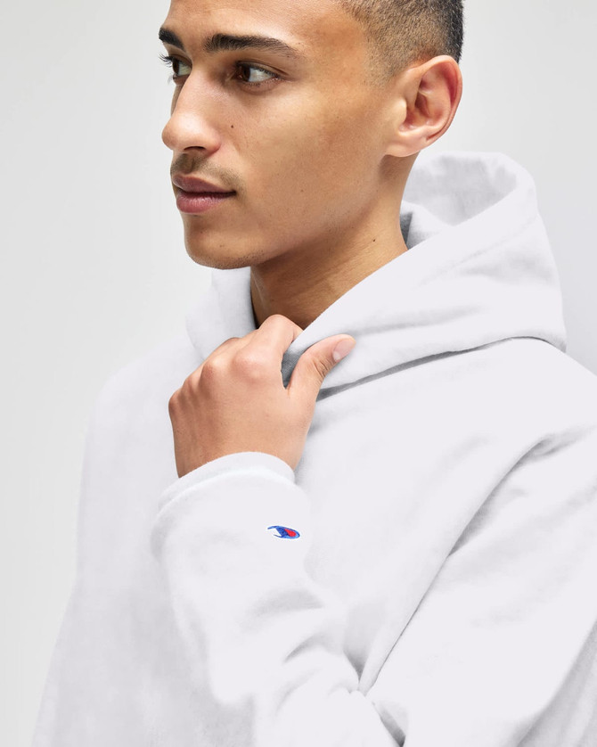 A grey hooded sweatshirt with a logo on the sleeve, featuring a male model looking to the side.