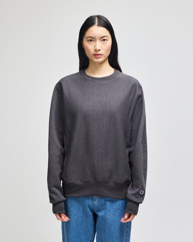 A grey pullover hooded sweatshirt with a relaxed fit and long sleeves. It features a logo on one sleeve.