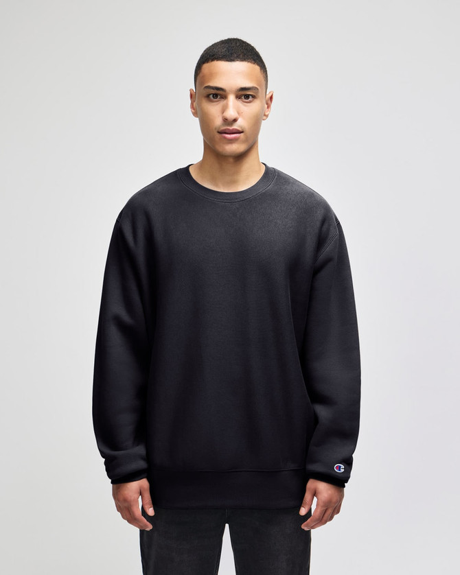 A black crew sweatshirt made from heavy fabric, featuring a logo on the sleeve.