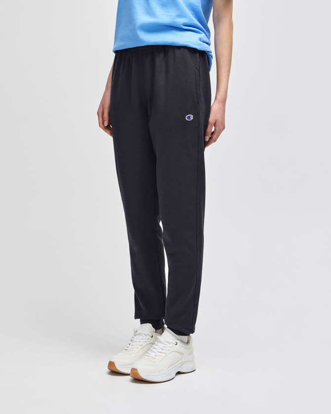 Black fleece jogger pants with an elastic waistband, featured alongside a blue top and white shoes.