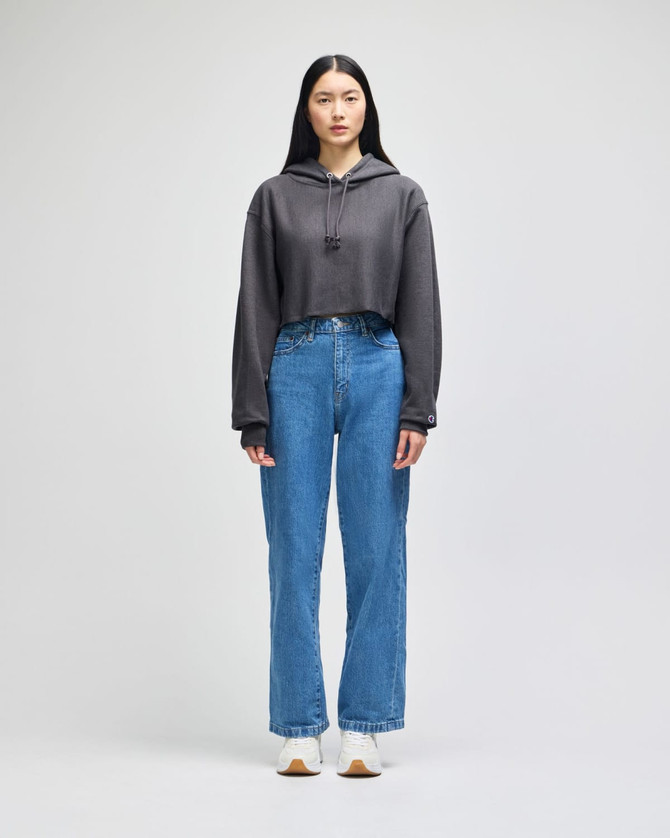A cropped hoodie in grey with a hood, paired with high-waisted denim jeans and white shoes.