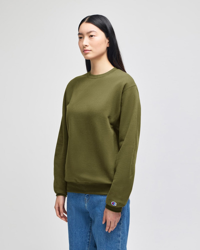 An olive green crewneck sweatshirt displayed on a model, featuring a logo on the sleeve.
