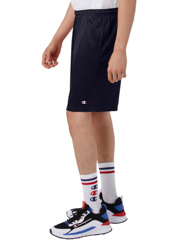 Navy sports shorts made of mesh, featuring pockets and a logo, displayed on a model with sporty shoes and socks.