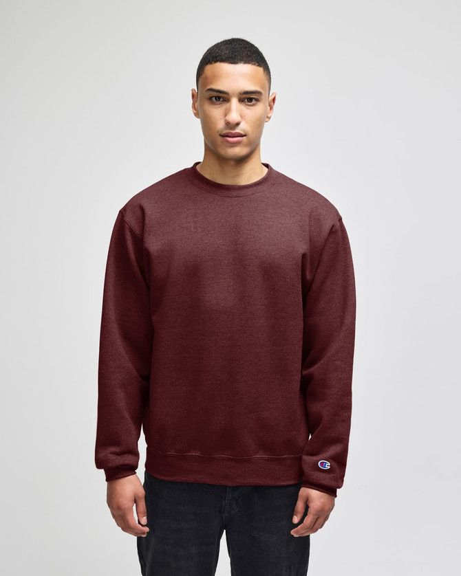 A maroon adult sweatshirt with a ribbed crew neckline and a logo on the sleeve, displayed on a model.