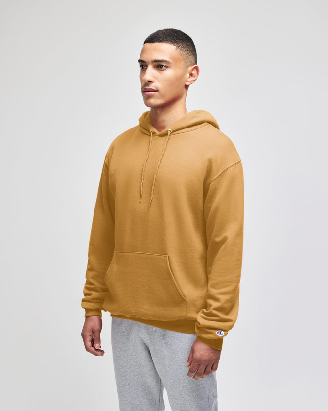 A man wearing a mustard yellow pullover hooded sweatshirt with a pouch pocket and a logo.