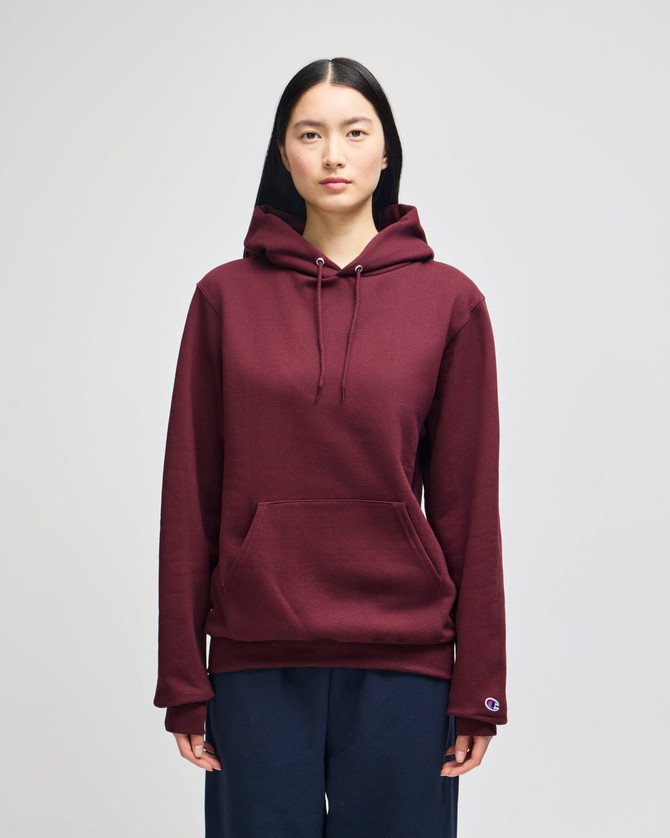 A burgundy hooded sweatshirt with a front pocket and a logo on the sleeve.