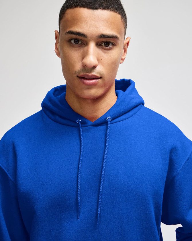 A blue pullover hooded sweatshirt with a front pocket and drawstring hood, worn by a model. It features a logo.