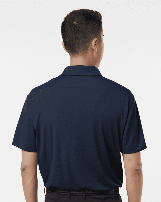 A navy blue men's polo shirt viewed from the back, featuring short sleeves and a collar. It has a logo on the chest area.