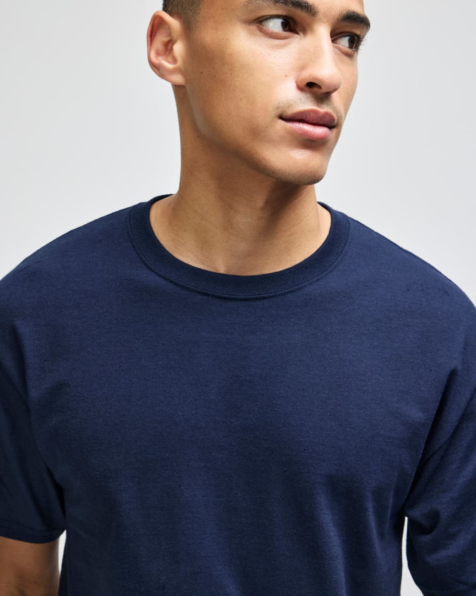 A navy blue Champion adult short-sleeve t-shirt displayed on a model. The t-shirt features a logo.