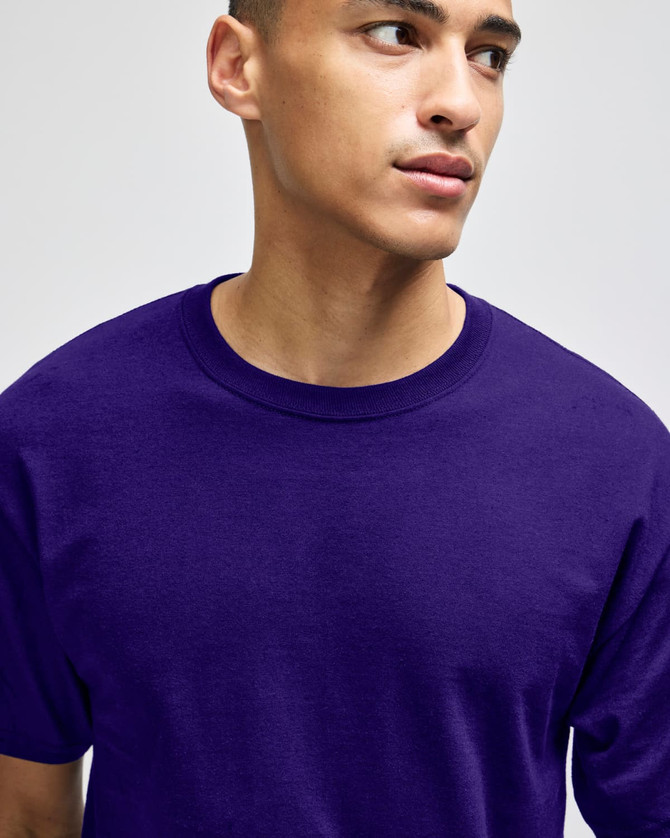 A purple Champion adult short-sleeve t-shirt displayed on a model. The t-shirt features a logo.