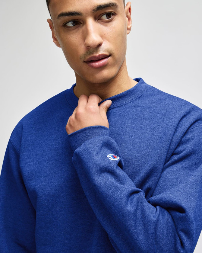 A blue Champion adult short-sleeve t-shirt with a logo, displayed on a model.