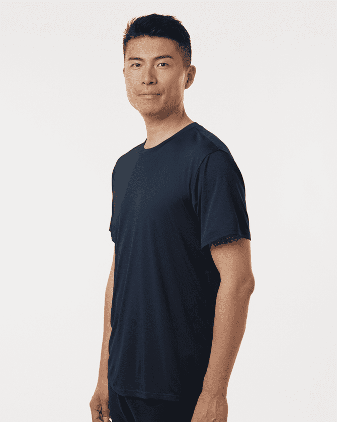 A man wearing a navy men's performance T-shirt, featuring a relaxed fit and minimal design.