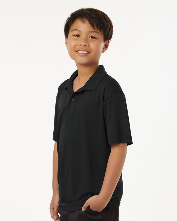A young boy wearing a black short-sleeved polo shirt with a collar. The shirt features a logo.