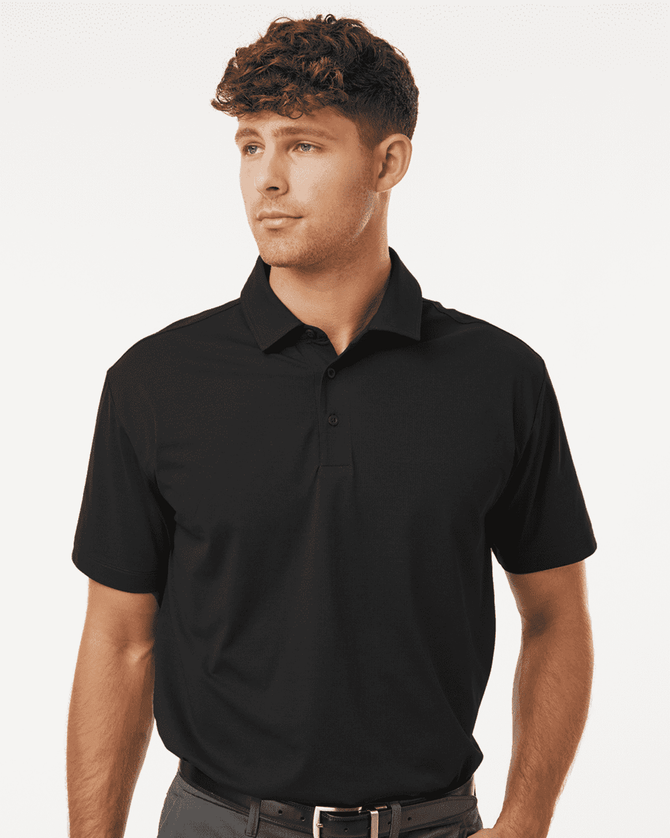 A black polo shirt with short sleeves, featuring a collar and a logo, modelled by a man.
