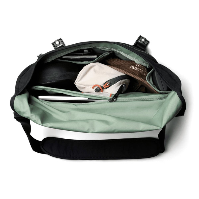 A black and mint green messenger bag opened to reveal multiple compartments, including a laptop sleeve and pouches.