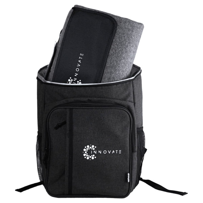 A black backpack with a large compartment containing a grey picnic blanket and an emblem on the front.
