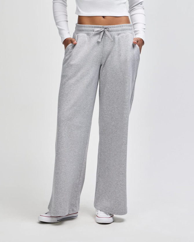 Wide leg pants in light grey, featuring an elastic waist and side pockets. The model wears a fitted top.