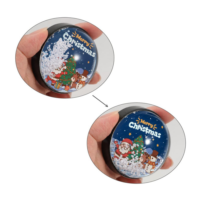 A snow globe fridge magnet in festive colours, featuring Christmas characters, including Santa, a tree, and a snowy scene.