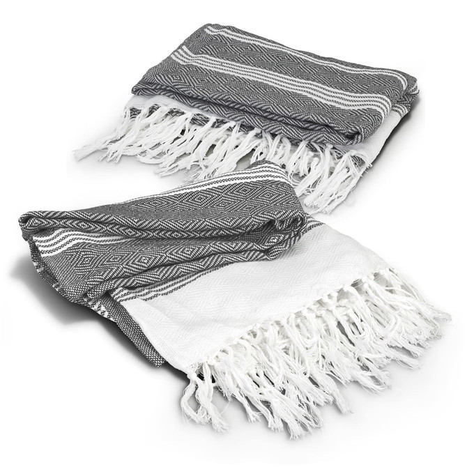 A grey and white Ohau Throw Blanket with tasselled edges, featuring a geometric pattern. It has a branding logo.