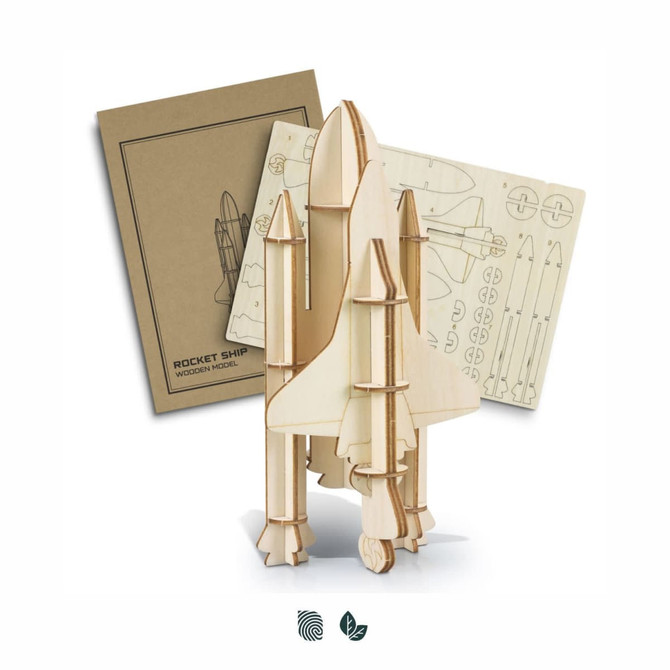 A wooden model of a rocket ship in natural wood tones, alongside assembly instructions and additional parts.