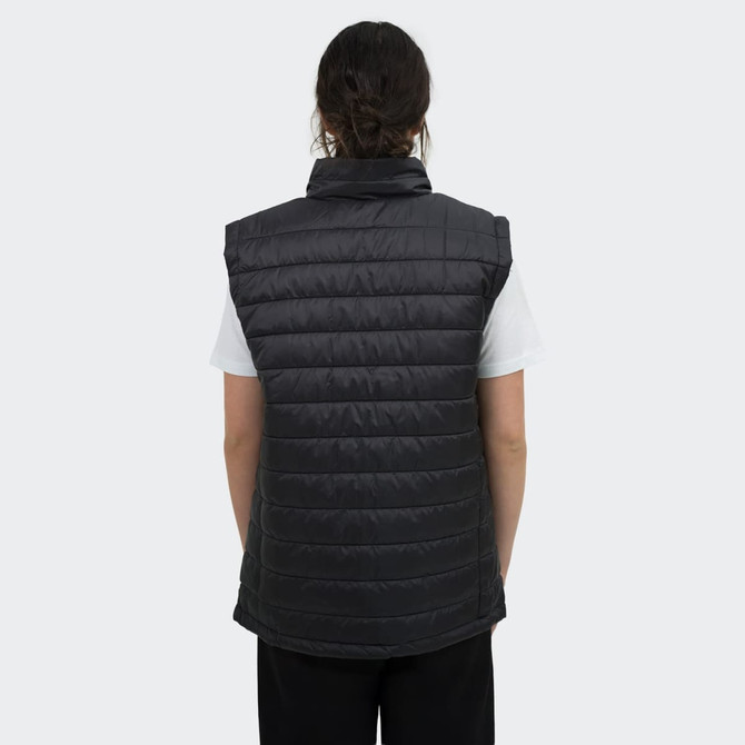 A women's puffer vest in black, featuring a high collar and a quilted design, worn over a white top.