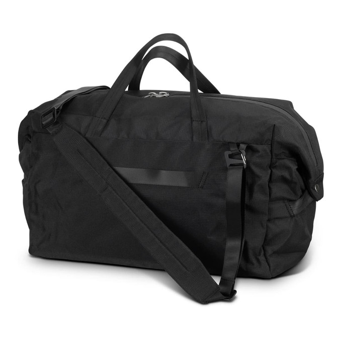 A black duffle bag featuring a shoulder strap and dual handles, with a simplistic design and a logo on it.