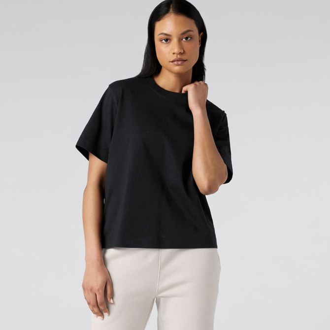 A black box tee featuring a relaxed fit and a simple design, worn by a model against a plain backdrop.