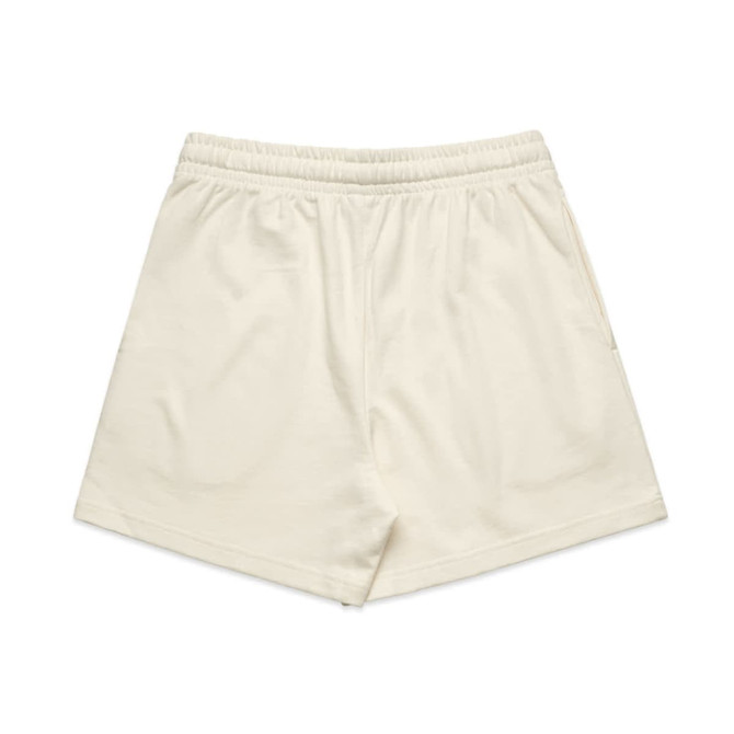 Cream-coloured sports shorts with an elastic waistband and a side pocket, featuring a logo.