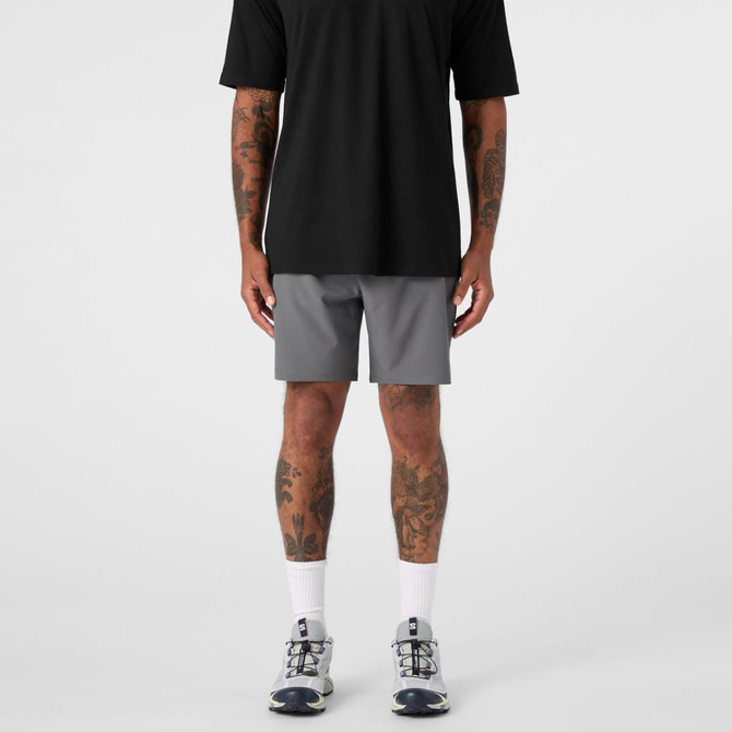 A pair of grey sports shorts paired with a black top, worn by a person with visible tattoos.