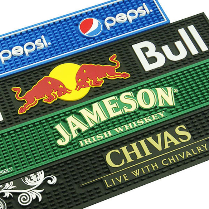 A collection of moulded PVC bar runners in blue, black, and green featuring various logos and colourful designs.