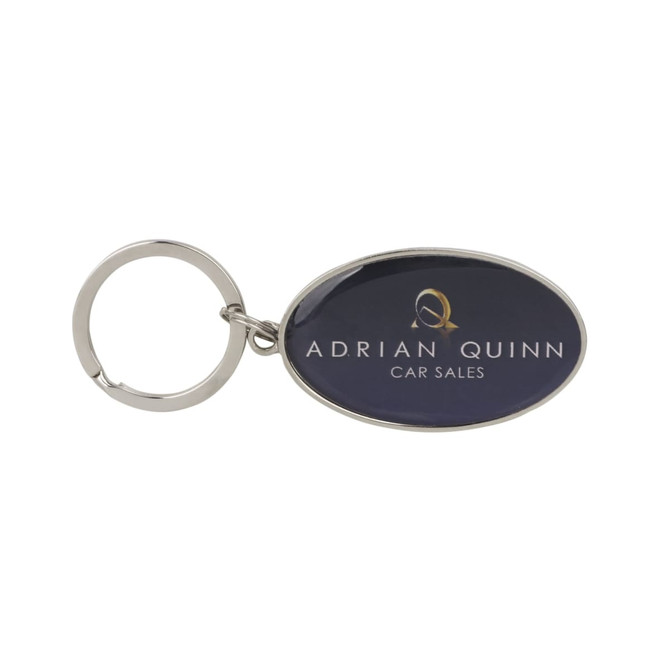 A metallic keyring with a silver ring and an oval epoxy domed surface featuring a logo.