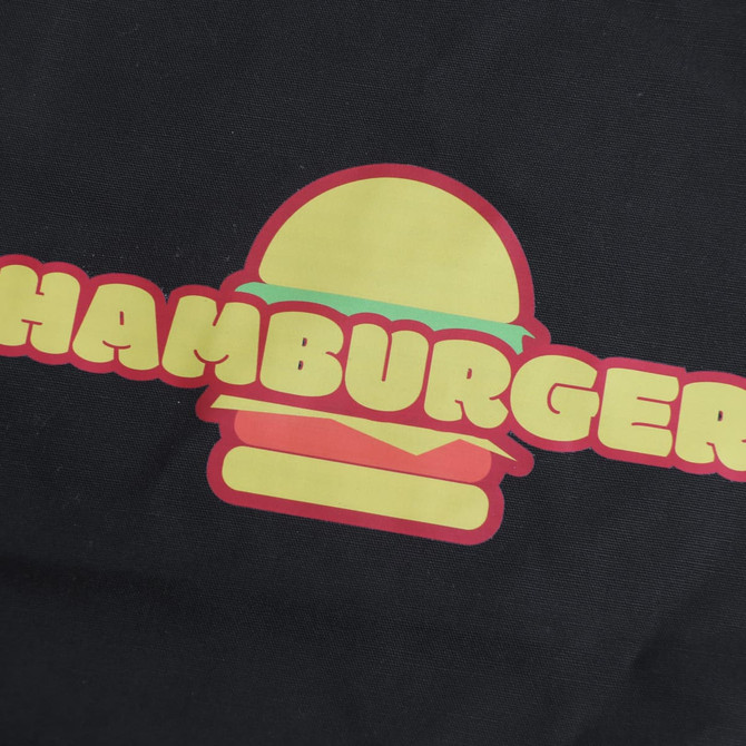 A black apron featuring a large, colourful hamburger graphic. The word "HAMBURGER" is prominently displayed beneath the graphic.