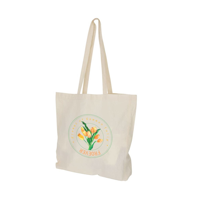 A cream-coloured calico bag with long handles and a floral graphic design, featuring a logo.
