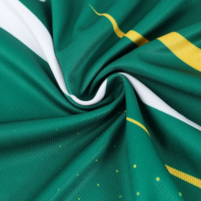 A green sports tee shirt made from 100% polyester, featuring yellow and white design elements and a logo.